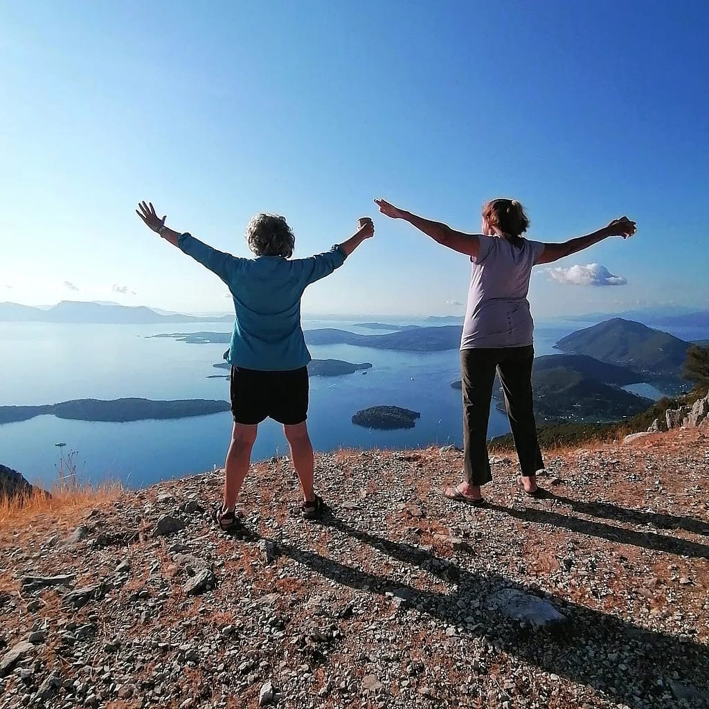 Due turiste felici che si godono il panorama mozzafiato dal balcone naturale della foresta di Skaros, immerso nella bellezza incontaminata di Lefkada.