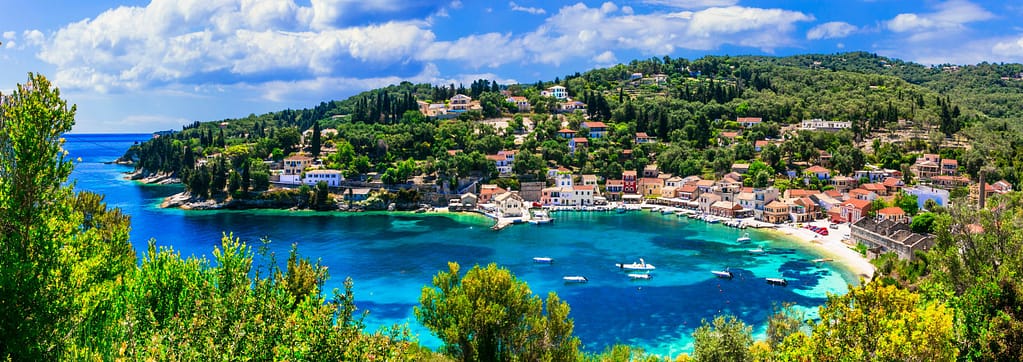 Vista panoramica del porto naturale di Paxos, una piccola baia protetta con acque cristalline e fondale trasparente.
