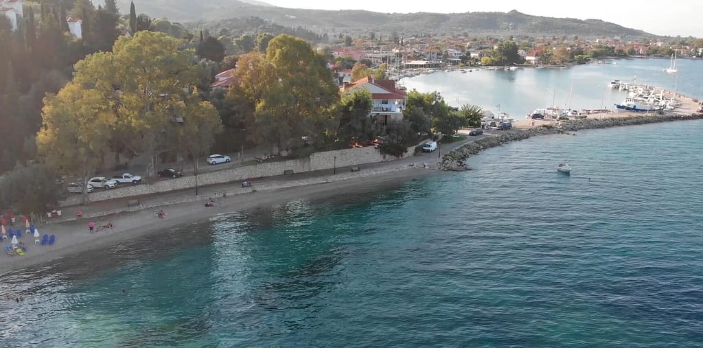 Vista alternativa della spiaggia e del porto di Ligya, Lefkada, con barche ormeggiate e litorale circostante.