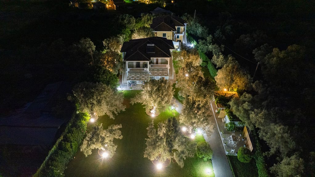 Vista notturna dell'esterno di Niki Apts, con l'illuminazione che evidenzia l'architettura e il giardino circostante