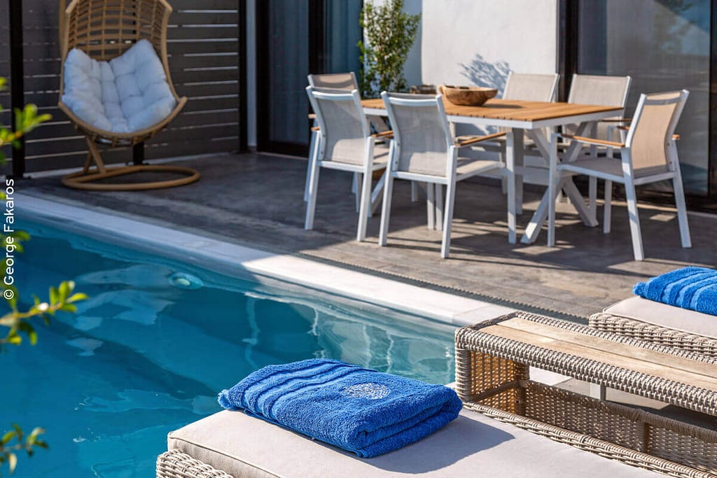 Dettagli della piscina e della tavola da pranzo esterna dei White Rock Apartments.