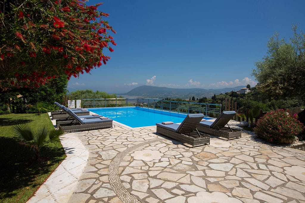 La piscina privata di Villa Petra, circondata da un'area relax con lettini, ideale per godersi il sole e la tranquillità in un ambiente esclusivo.