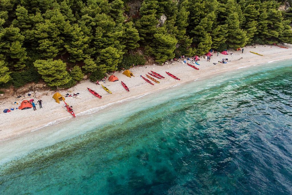 Un kayak naviga nelle acque cristalline di Lefkada, immerso in paesaggi naturali durante un'avventura di 3 giorni tra mare e campeggio.