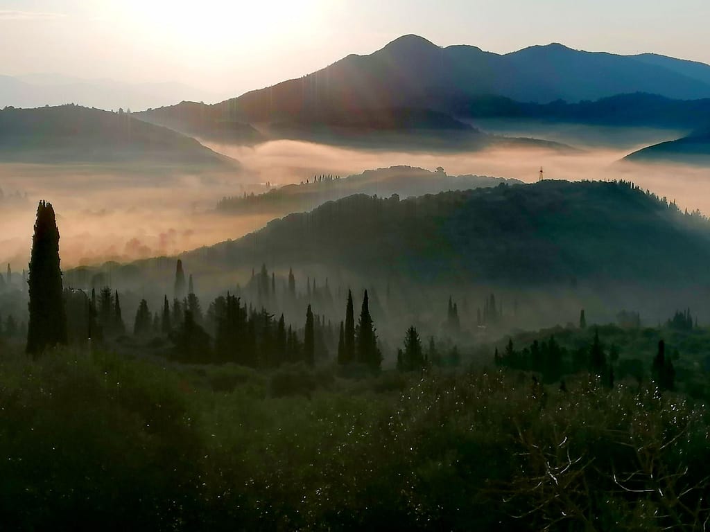 Un paesaggio emozionante all'interno di Lefkada al mattino presto, con una coltre di bruma che sfuma il profilo delle montagne, le valli e l’altopiano.