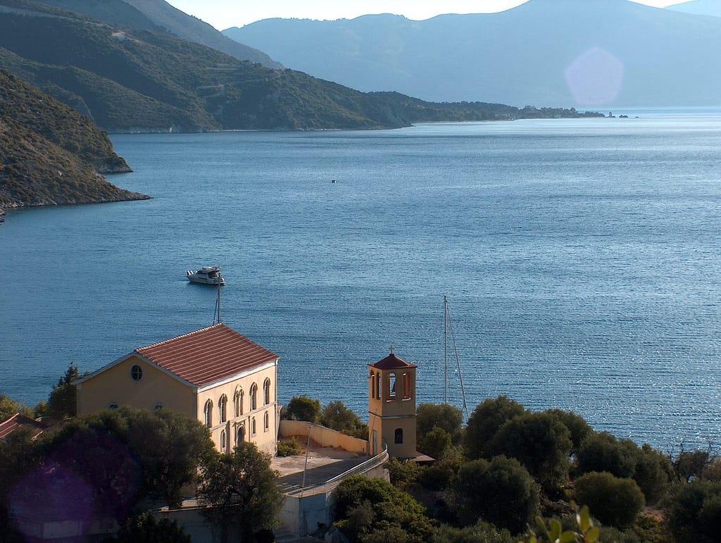 Vista panoramica di Porto Leone, con la chiesa del villaggio abbandonato in fondo alla baia di Kalamos.