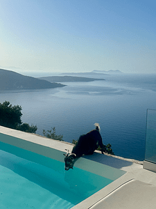 Un’immagine suggestiva di una capra che si ferma a bere, circondata dalla natura incontaminata che avvolge le Ourania Villas, in un paesaggio tranquillo e autentico.