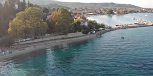 Vista alternativa della spiaggia e del porto di Ligya, Lefkada, con barche ormeggiate e litorale circostante.