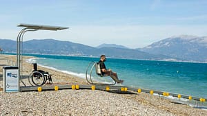 Persona su un apposito sea-track: sedia adattata che utilizza una passerella d'accesso al mare per disabili.