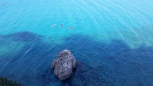 Agios Ioannis. Bagnanti immersi nell’acqua turchese lungo questo tratto di costa.
