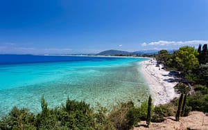 Ampio litorale di Agios Ioannis, caratterizzato da acque limpide e paesaggio aperto.