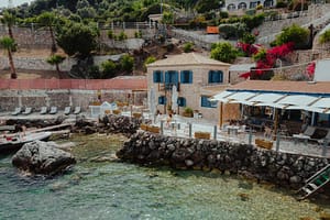 Vista della sezione sul mare del Sea Mansion, con un’ampia terrazza al livello dell'acqua, molo privato e area relax attrezzata con lettini.