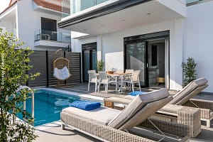 Dettagli della piscina e dei lettini relax esterni dei White Rock Apartments.