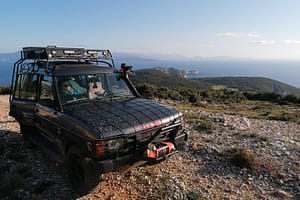 L'auto di Giannis si avvicina all'estremo sud dell'isola di Lefkada, con la vista in lontananza della fine dell'isola delimitata da Capo Lefkata e dal leggendario faro.