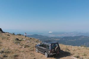 La Land Rover Best del pilota esperto Giannis, parcheggiata su un balcone naturale con una vista mozzafiato del paesaggio circostante.