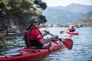 Un partecipante al tour in kayak esplora un tratto di costa a Lefkada, godendo della bellezza naturale e delle acque cristalline durante la sua avventura.