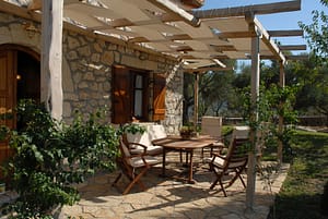 Area pranzo esterna con pergola e vista sul giardino di Villa Marina