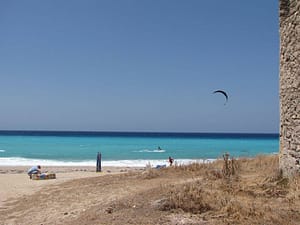 Panorama che si apre dietro un mulino sulla spiaggia di Agios Ioannis, con il mare e il paesaggio circostante di Lefkada.