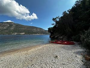 Kayaks allineati sulla spiaggetta tranquilla prima di iniziare il tour verso la splendida Dessimi Bay a Lefkada.