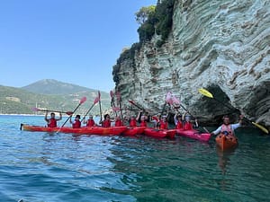 Kayaks allineati in acque tranquille vicino alla riva, pronti per una foto ricordo prima di continuare l'avventura in kayak a Lefkada.