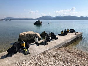 Equipaggiamento subacqueo in attesa sul molo di fronte al Lefkas Diving Center, pronto per la lezione di diving.