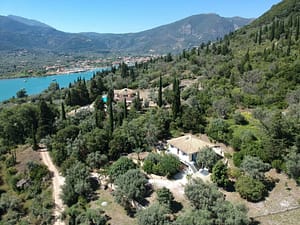 Casa Asteri vista aerea Vista aerea di Casa Asteri a Geni, Lefkada, con il grande giardino che si fonde nella natura circostante e il villaggio di Nidri sullo sfondo.