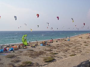 Kitesurfisti in azione sulla spiaggia di Agios Ioannis, in una giornata ventosa.