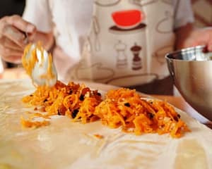 mmagine di un corso di cucina alla micro farm, durante il trattamento degli ingredienti naturali, mentre gli studenti seguono una preparazione guidata per una ricetta.