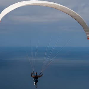 Un parapendio in volo sopra il mare di Lefkada, con le sue sfumature turchesi e blu.