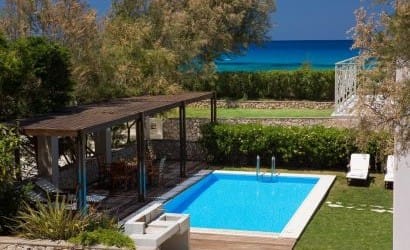 Giardino di Ammos Aeriko Villas a Lefkada con piscina e vista mare dal balcone del primo piano, sullo sfondo il mare di Agios Ioannis con sfumature indaco.