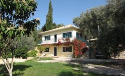 Casa Asteri a Geni, Lefkada, circondata da un giardino rigoglioso e una vista sulla baia di Vlicho, ideale per soggiorni estivi e relax nella natura.