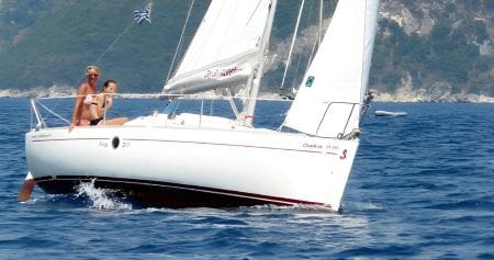 Il Beneteau 21.1 in navigazione di bolina vicino alla costa di Meganissi, con due giovani donne a bordo che manovrano con padronanza acquisita durante un corso della scuola di vela Lefkada First.
