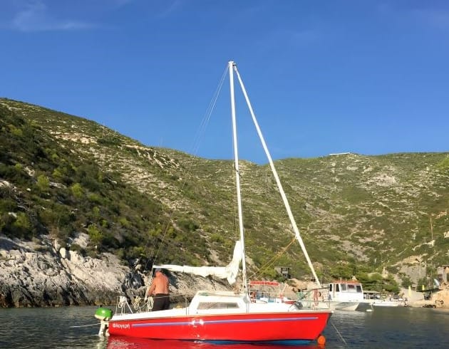 Flogherì, Caprice di 19 piedi, barca a vela utilizzata per l'apprendimento velico a Lefkada, in primo piano sul mare cristallino.