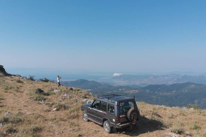 La Land Rover Best del pilota esperto Giannis, parcheggiata su un balcone naturale con una vista mozzafiato del paesaggio circostante.