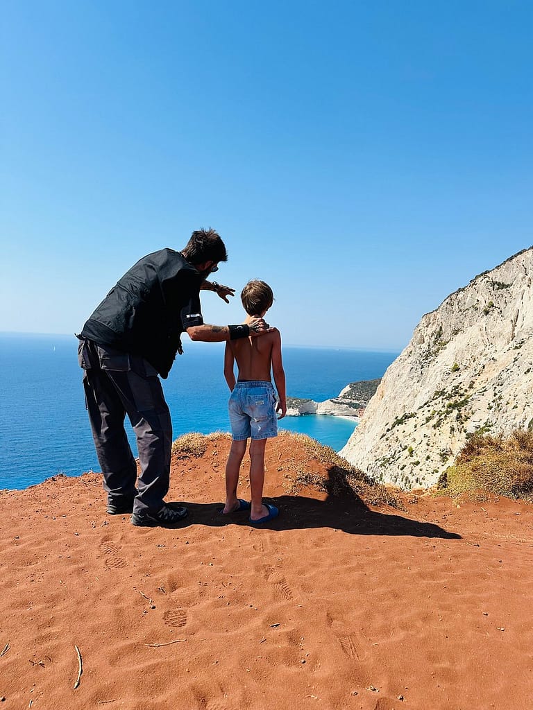 Yannis spiega la meraviglia del Capo Lefkata, situato all'estremità meridionale dell'isola di Lefkada, a un giovane esploratore.