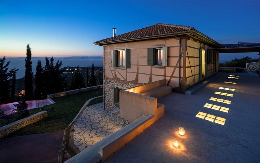 Vista suggestiva di Melivaro Villa all'imbrunire, immersa tra le colline di Lefkada, con un cielo sfumato nei colori del tramonto.