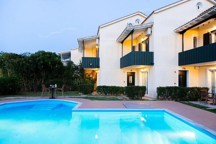 Piscina all'aperto di Villa Altina con vista sull'edificio formato da tre appartamenti, ognuno con tre camere da letto.