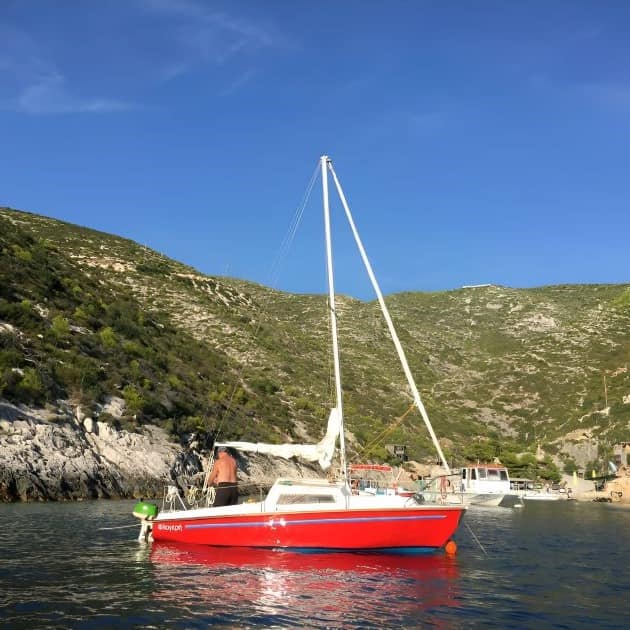 Flogherì, Caprice di 19 piedi, barca a vela utilizzata per l'apprendimento velico a Lefkada, in primo piano sul mare cristallino.